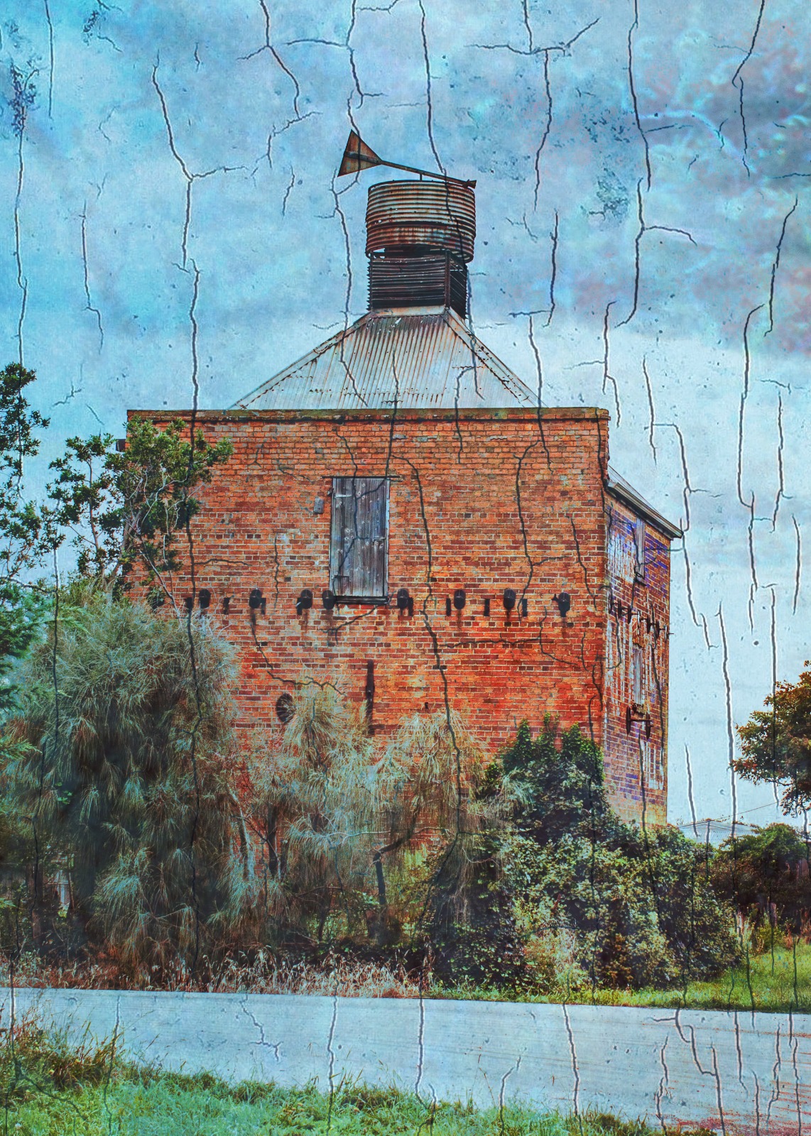 A weathered brick outbuilding with roof tank rising above scrub and rough vegetation.